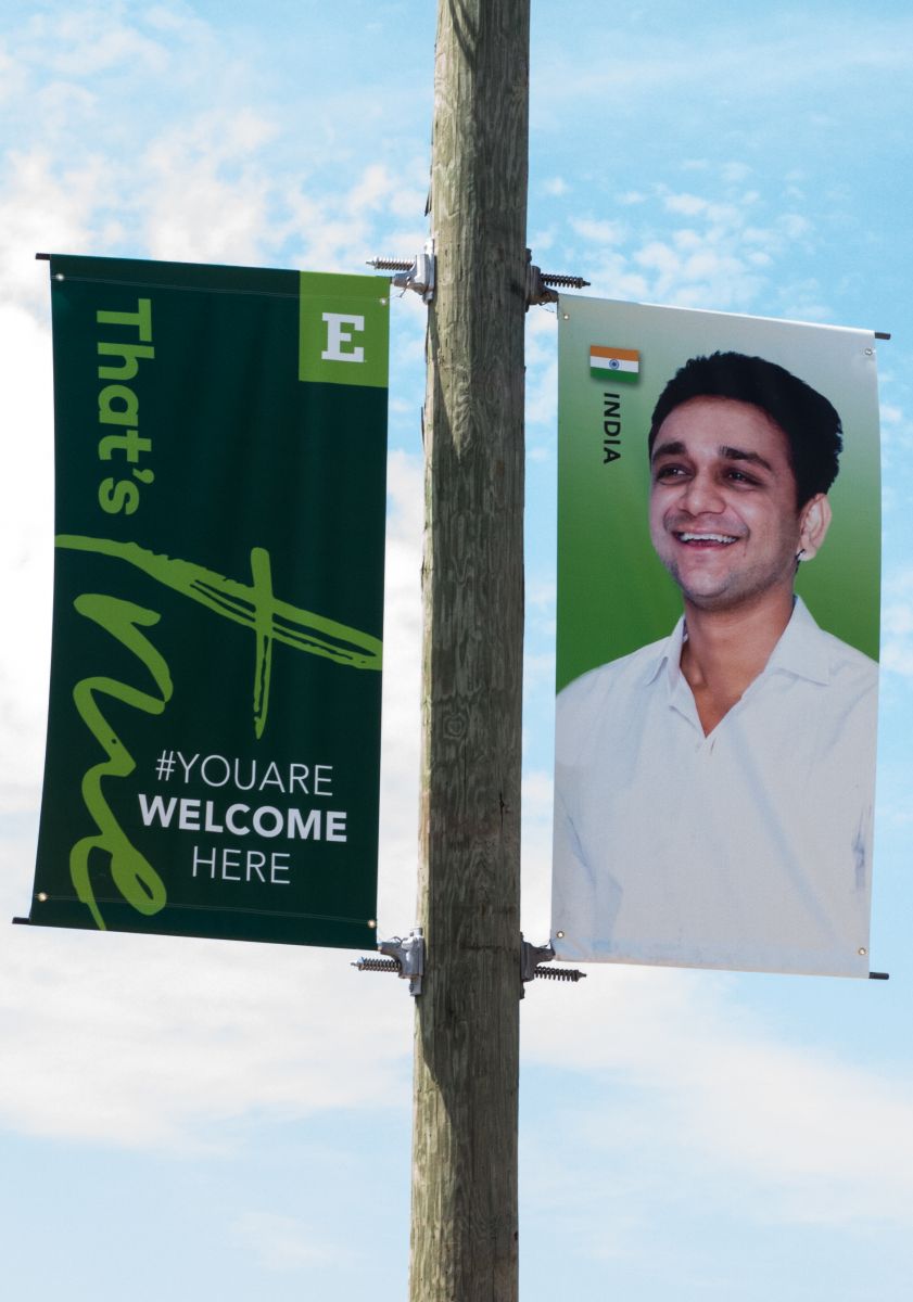 Banner on Eastern Michigan campus with "That's true, you are welcome here" and photo of an international student from India.